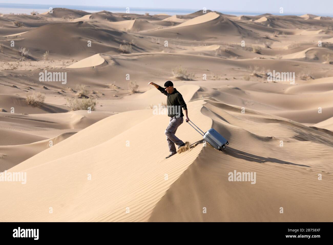 Imagen simbólica: Turista con maleta en el desierto, Desierto de Mesr,  Irán. El desierto de Mesr es parte del desierto central en Irán. [traducción  automática] Fotografía de stock - Alamy