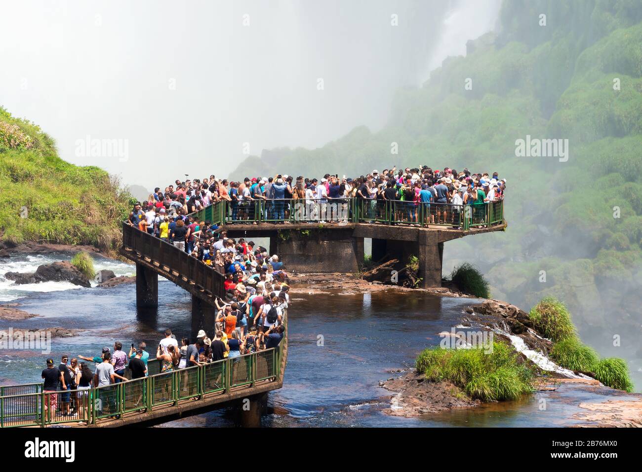 Una enorme multitud de turistas sobre una pasarela en el Parque Nacional de las Cataratas del Iguazú, resultado del turismo excesivo durante el Carnaval y las vacaciones populares. Foz do Iguaçu Foto de stock