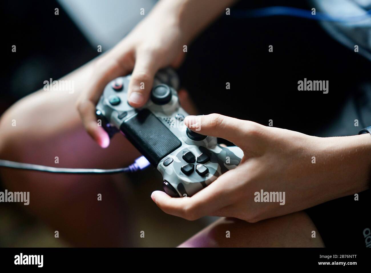 Un primer plano de un dispositivo de videojuegos mientras juega un adolescente. Foto de stock