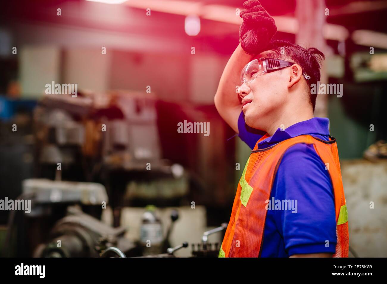 Trabajador cansado, dolor de cabeza tiempo caliente sobre calor mal ingeniero que trabaja en la industria pesada fábrica. Foto de stock