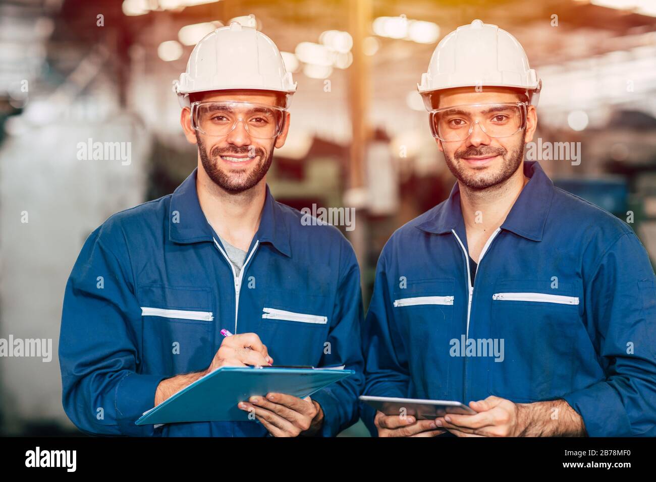 Retrato de un feliz trabajo en equipo de ingenieros sonriendo mirando la cámara. Foto de stock