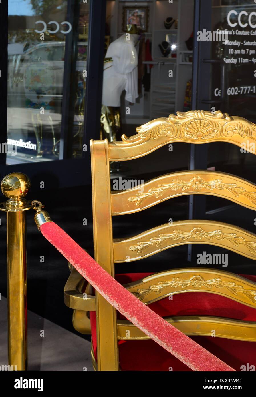 Una silla de marido en oro dorado y terciopelo rojo con cuerdas delante de la  boutique de moda italiana de lujo, Carolina's Couture Collection en el casco  antiguo de la ciudad S
