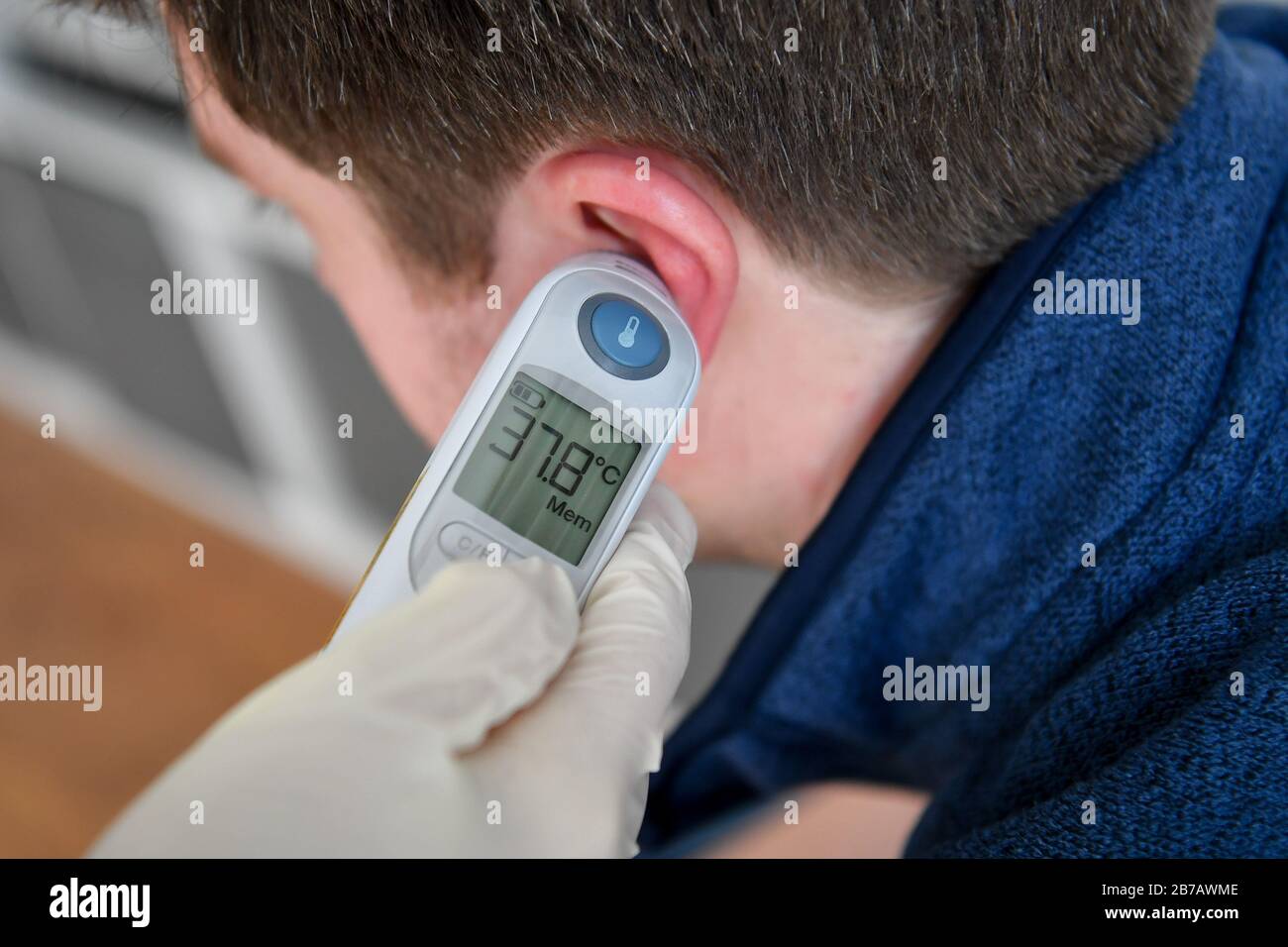 La imagen PLANTEADA POR MODELO temperatura corporal de 37.8 grados Celsius  se registra en un hombre usando un termómetro timpánico. Foto PA. Fecha Del  Cuadro: Sábado 14 De Marzo De 2020. El