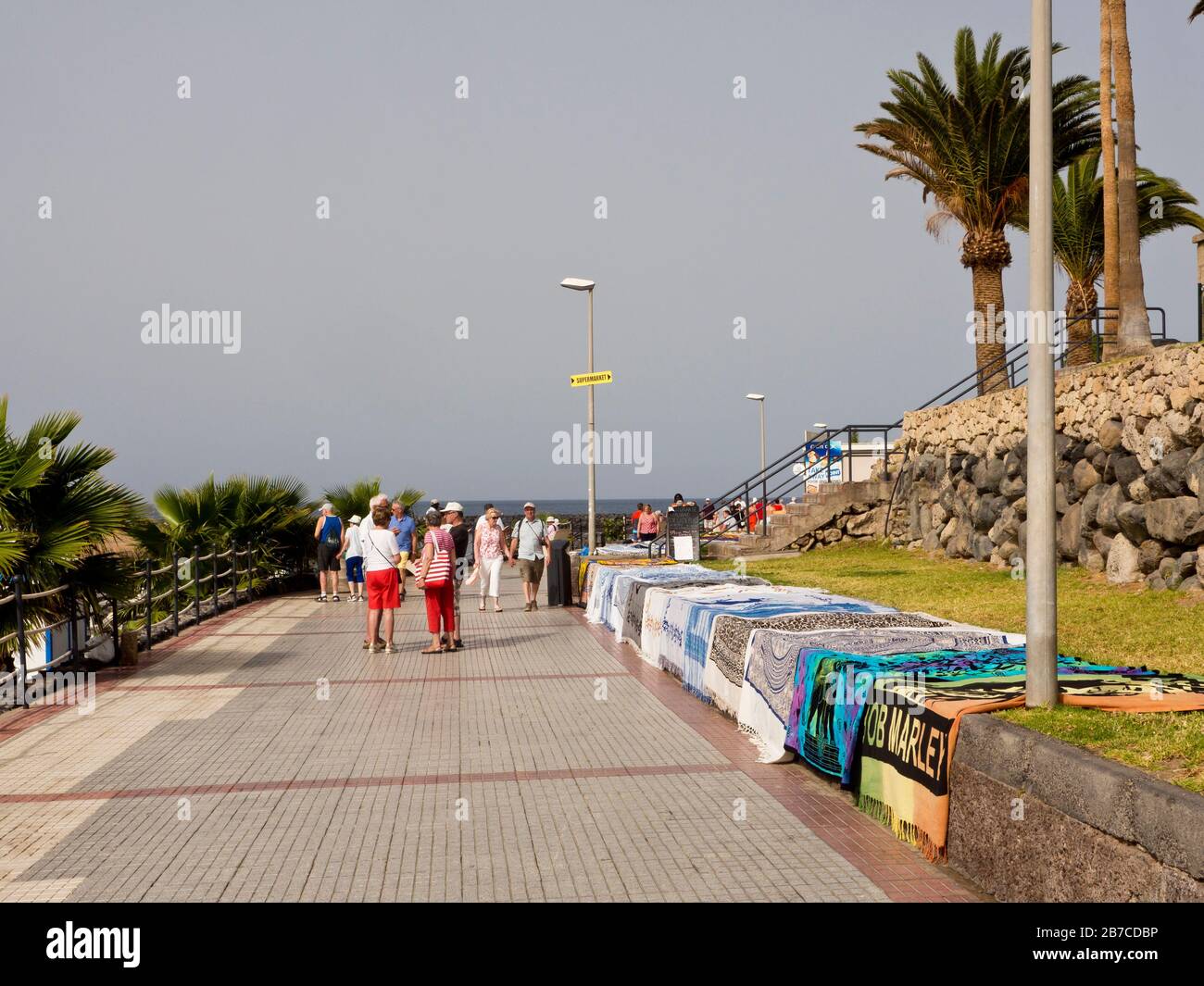 Telas coloridas que ofrecen a los turistas vendedores ambulantes en el paseo marítimo de Costa Adeje, Islas Canarias España Foto de stock