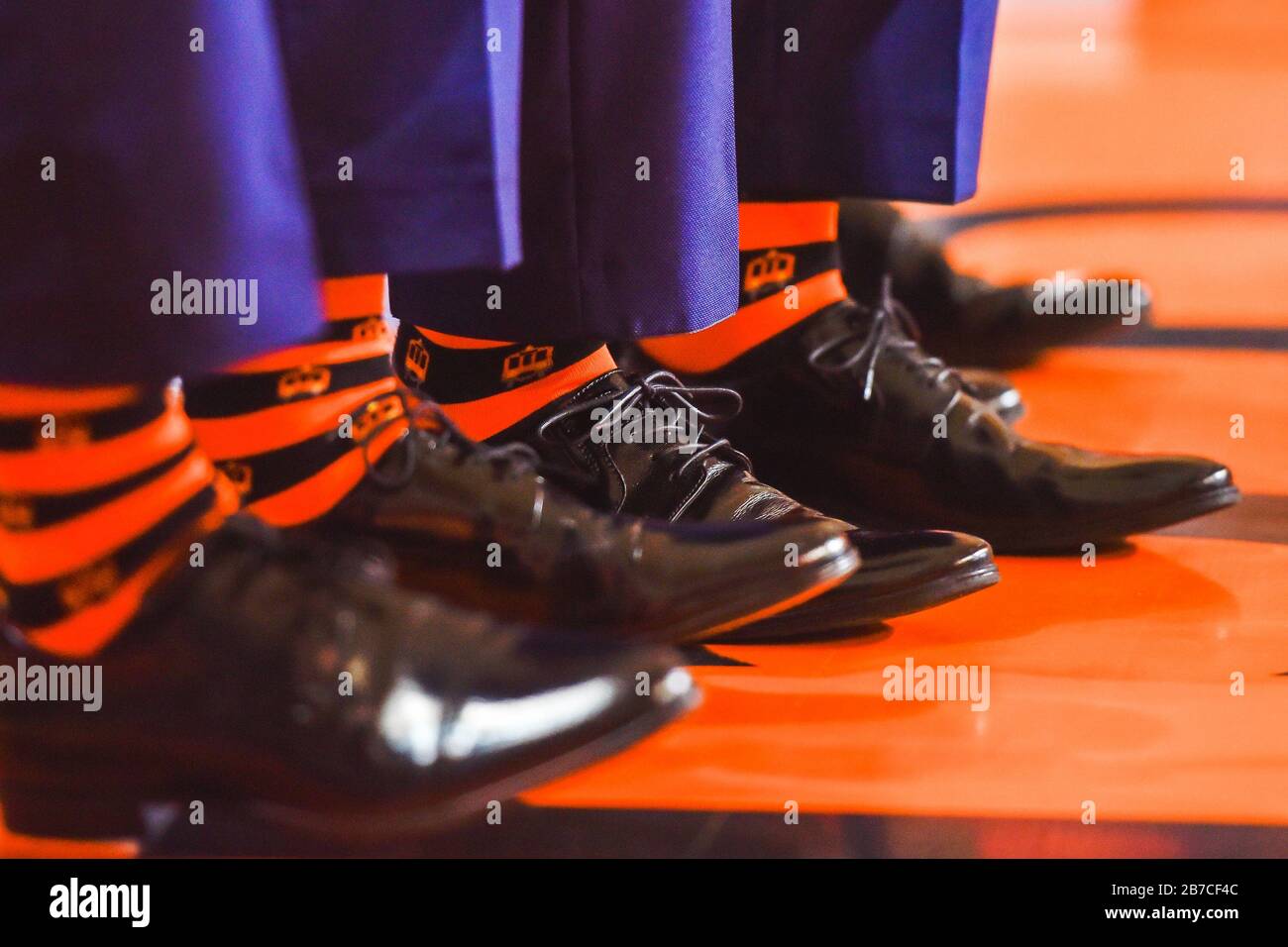 Piernas con zapatos negros y calcetines naranjas. Foto de stock