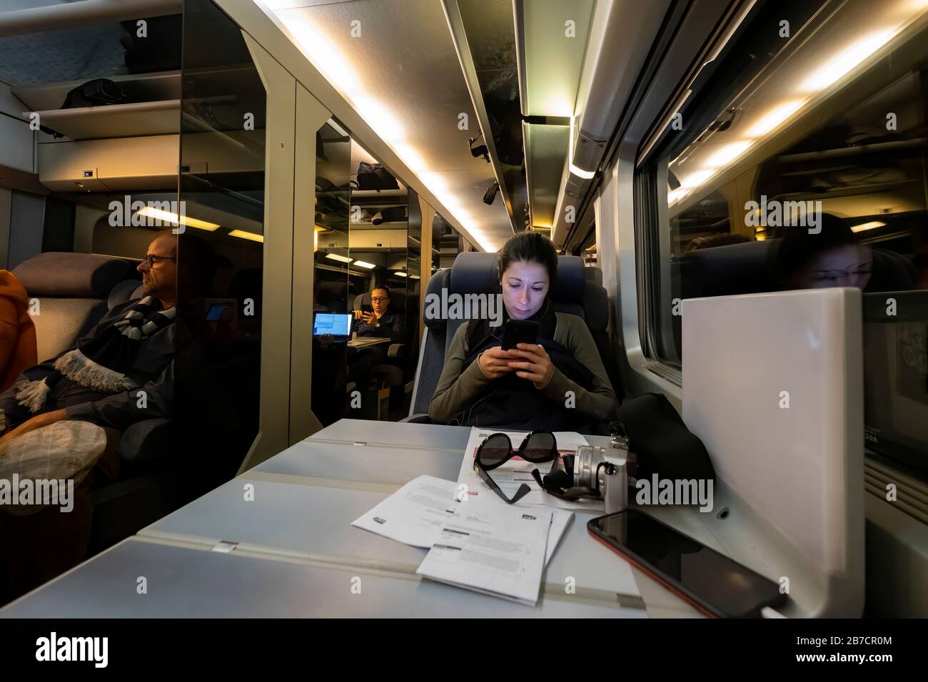 Mujer joven utilizando su smartphone en primera clase en el tren de alta velocidad TGV, Gare Montparnasse, París, Francia, Europa Foto de stock