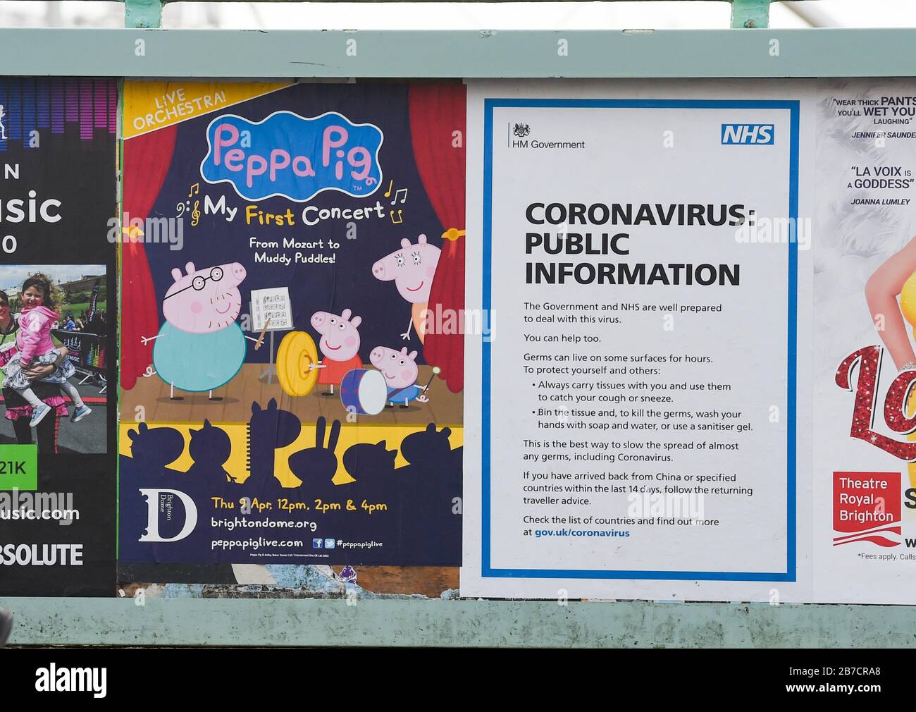 Brighton Reino Unido 15 de marzo de 2020 - un cartel de información pública de Coronavirus de NHS junto con un cartel anunciando un espectáculo de Peppa Pig en el paseo marítimo de Brighton hoy: Crédito Simon Dack / Alamy Live News Foto de stock