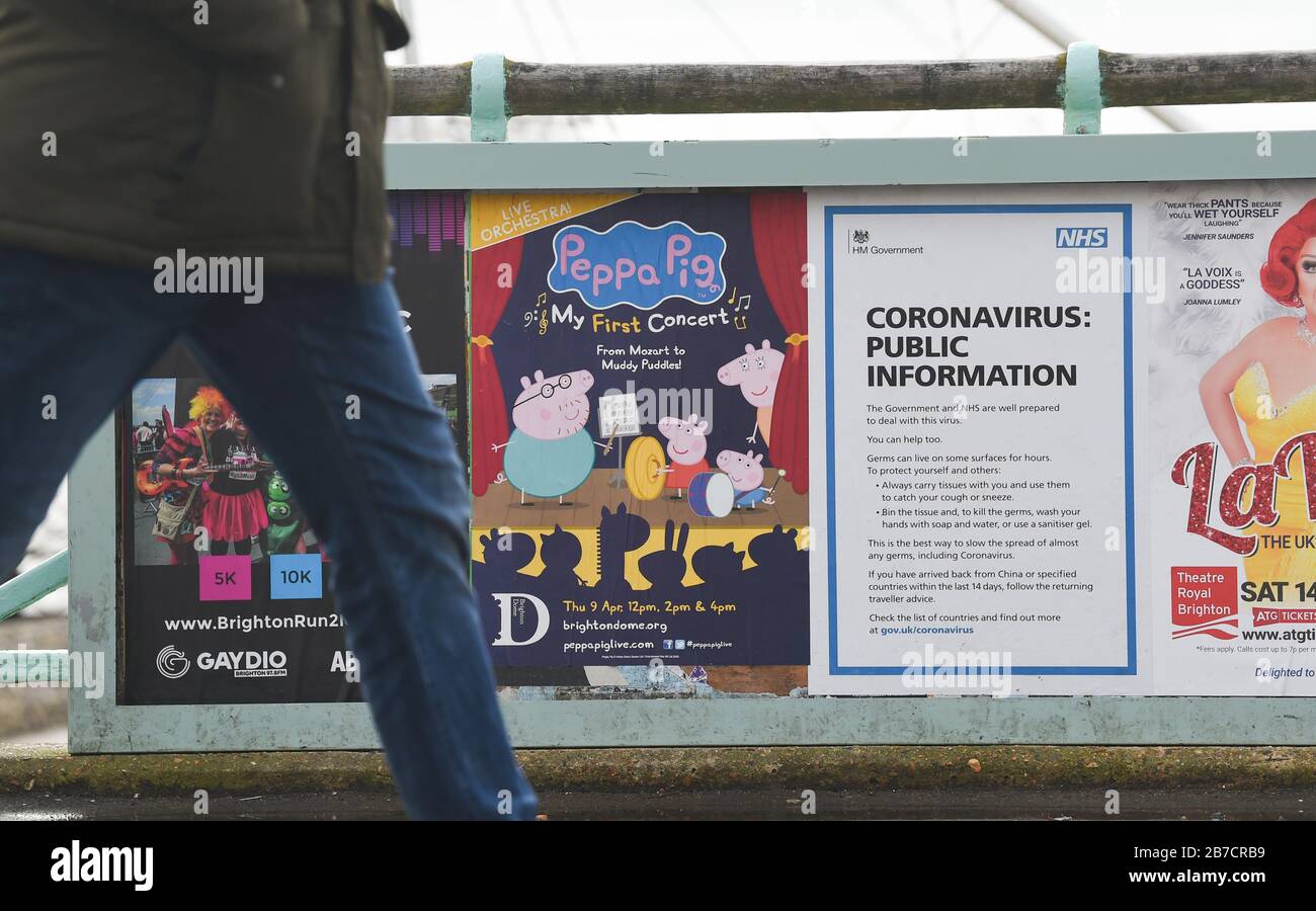 Brighton Reino Unido 15 de marzo de 2020 - un cartel de información pública de Coronavirus de NHS junto con un cartel anunciando un espectáculo de Peppa Pig en el paseo marítimo de Brighton hoy: Crédito Simon Dack / Alamy Live News Foto de stock