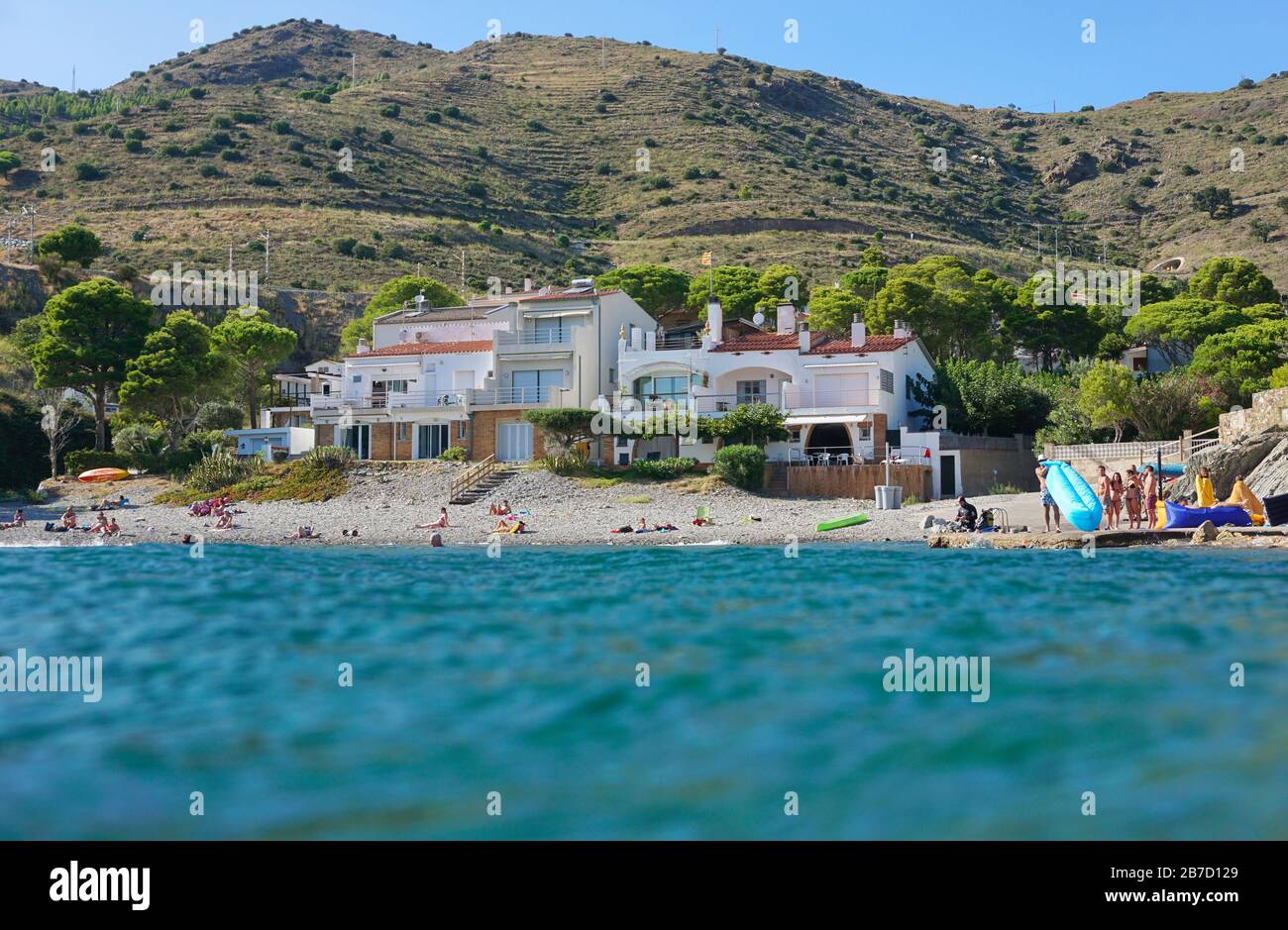 COLERA, CATALUÑA, ESPAÑA – 08/21/2019: Vacaciones de verano en el mar Mediterráneo, costa costera con edificios vistos desde la superficie del agua, Costa Brava Foto de stock