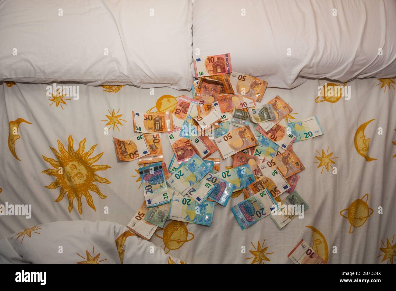 Dinero en la cama, euros, cuentas y sábanas Foto de stock