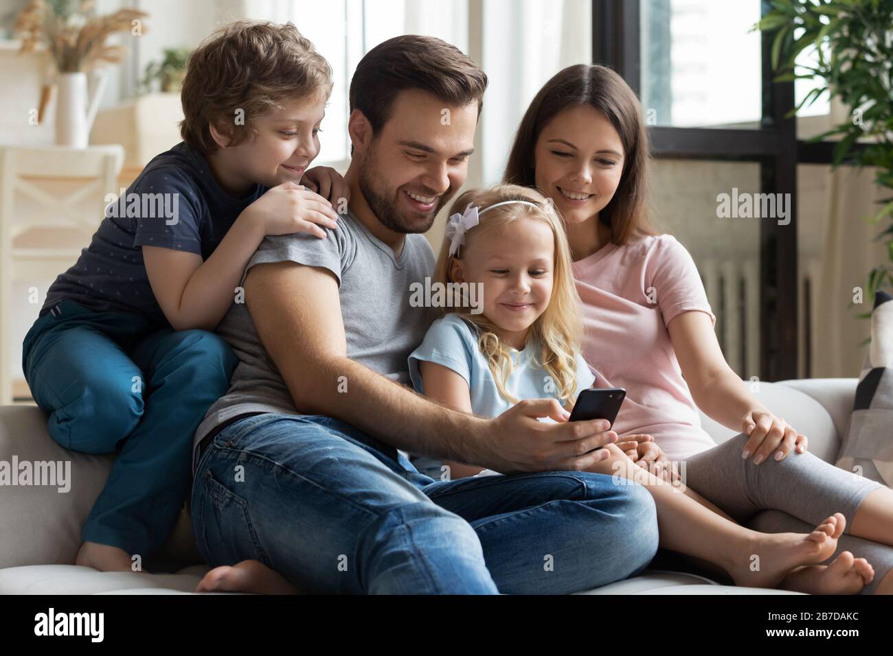 Feliz familia con los niños disfrutando de vídeo en la celda Foto de stock