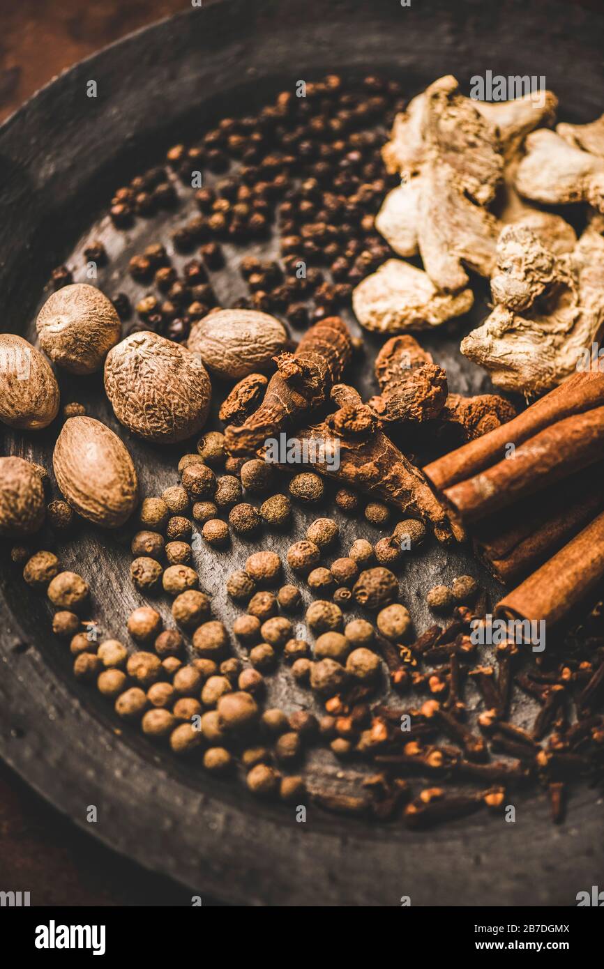 Mezcla tradicional turca de siete especias Yedi Bahar para cocinar. Pimienta negra, jengibre, clavo, nuez moscada, canela, pimienta alpinia y raíz de alpinia en placa negra o. Foto de stock