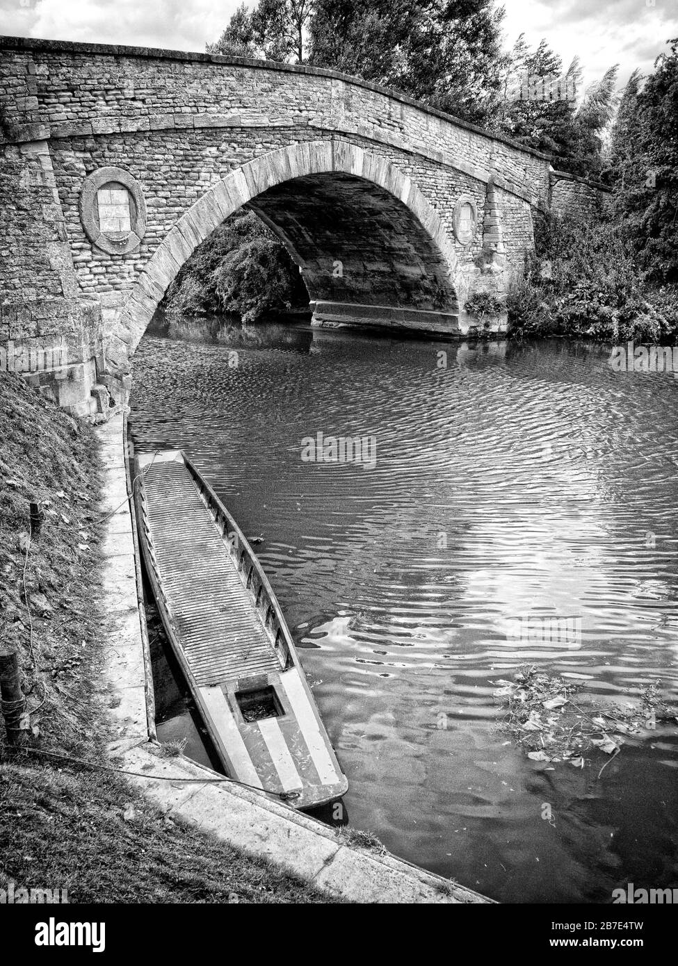 Punt amarrado por un puente medieval sobre el río Támesis cerca de Oxford Foto de stock