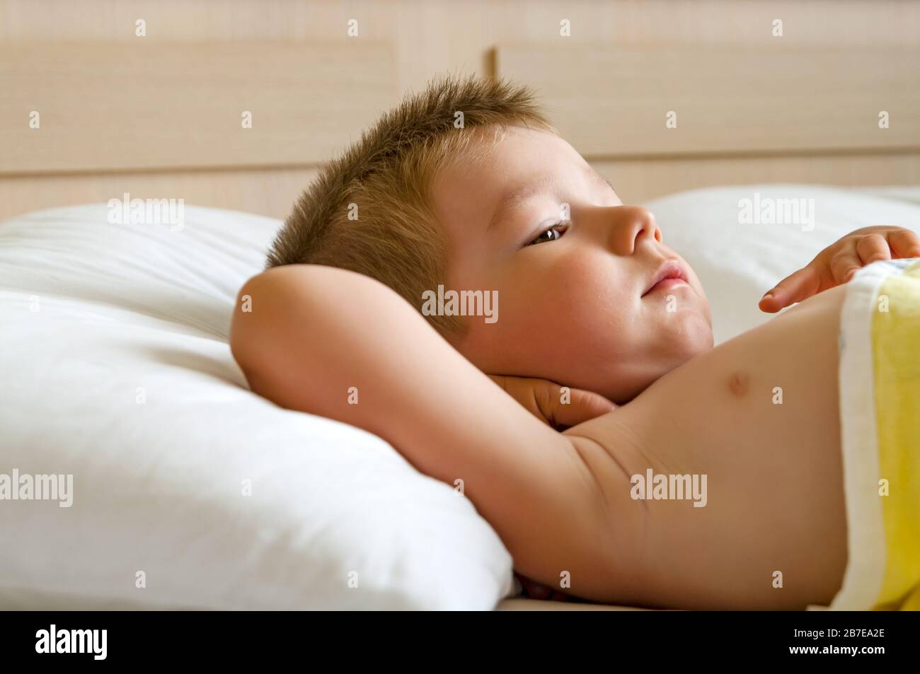 Lindo niño acostado en la cama antes de dormir. Foto de stock