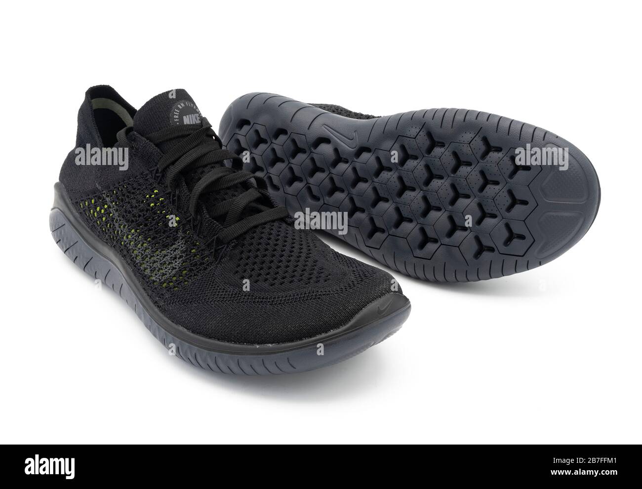 Par de zapatillas de running de verano ventiladas Free RN Flyknit negras sobre fondo blanco Fotografía stock -