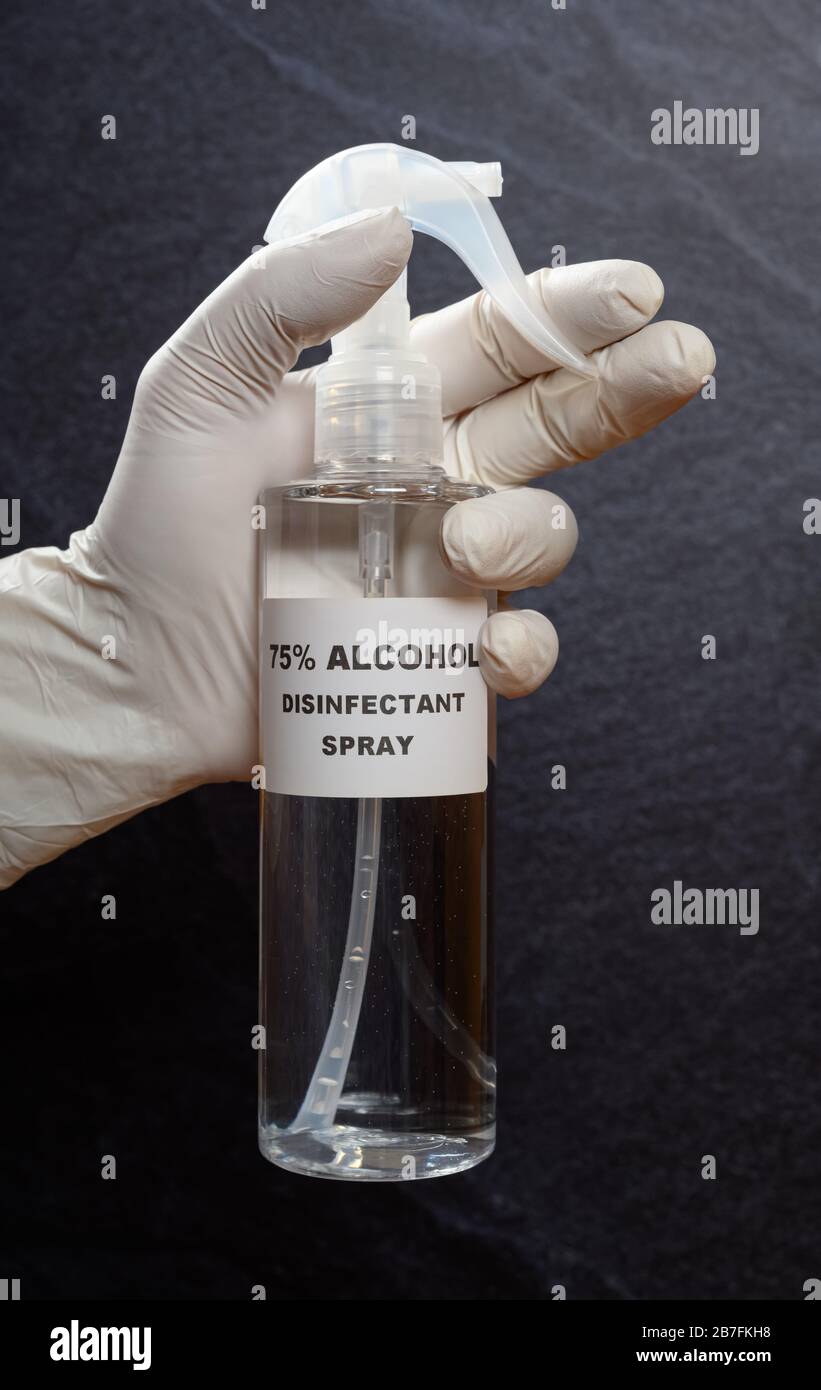 hombre sosteniendo una botella de alcohol desinfectante 75 por ciento spray que se usa para matar el coronavirus Foto de stock