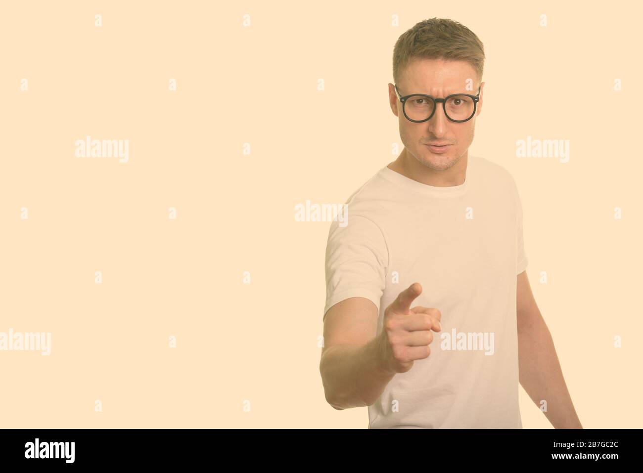 Retrato de un hombre nerd estresado con gafas apuntando a la cámara Foto de stock