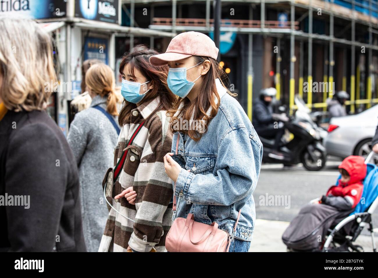 Los viajeros toman precauciones al usar máscaras faciales en el West End de Londres contra la infección de la pandemia de Coronavirus Covid19, Inglaterra, Reino Unido Foto de stock