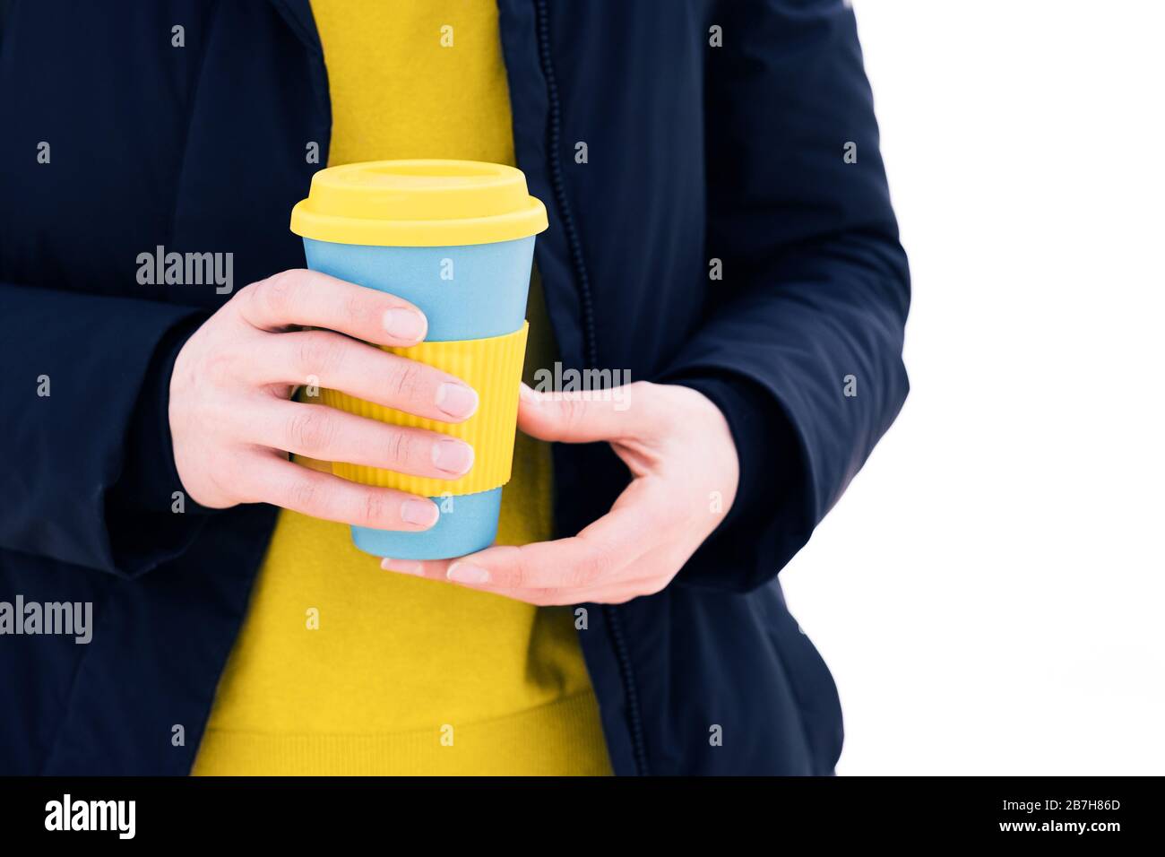Sujeción de la mano elegante taza de café ecológico reutilizable al aire libre. Saque el café Foto de stock