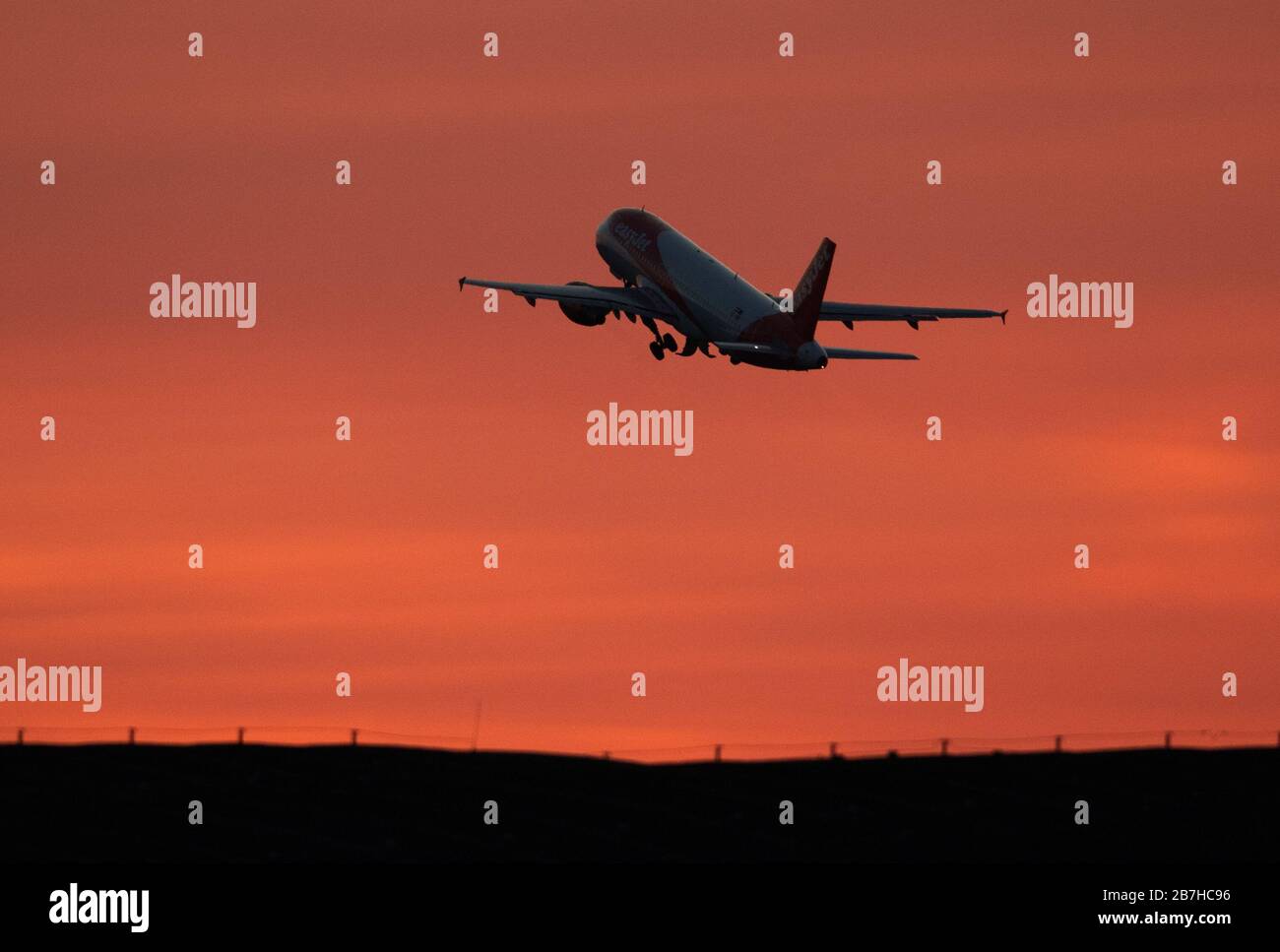 15 de marzo de 2020, Brandeburgo, Schönefeld: Un Airbus A320-200 Sharklet de la línea aérea easyJet despida del aeropuerto de Schönefeld frente al cielo rojo de la tarde hacia Londres. Foto: Soeren Stache/dpa-Zentralbild/ZB Foto de stock