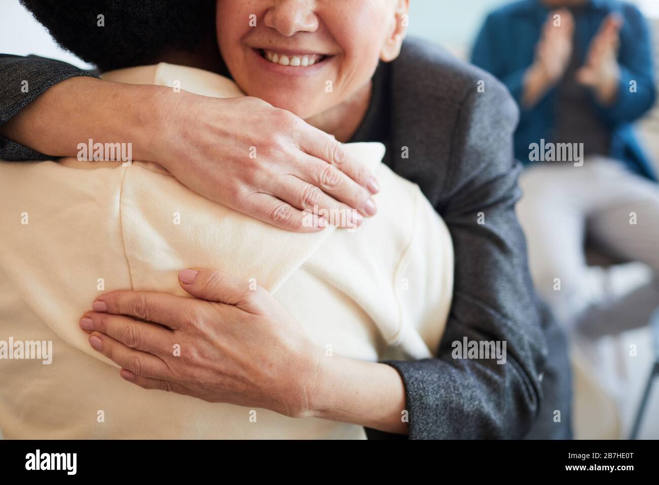 Primer plano de una psicóloga sonriente que abraza a un adolescente afroamericano durante una sesión de terapia en un grupo de apoyo, espacio de copia Foto de stock