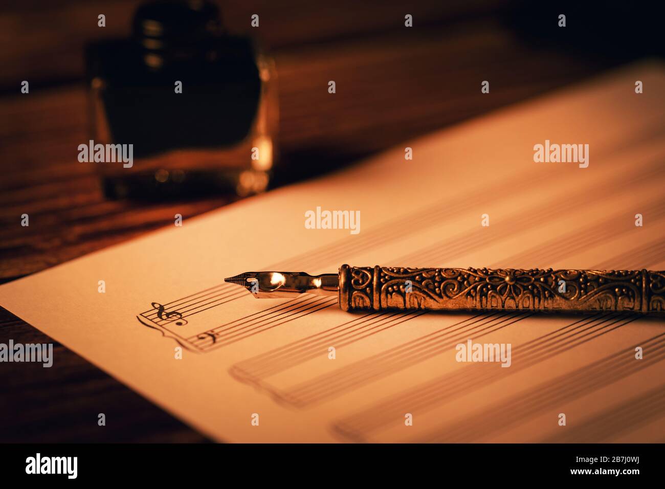 pluma de pluma vintage en la hoja de notas de música en blanco Foto de stock