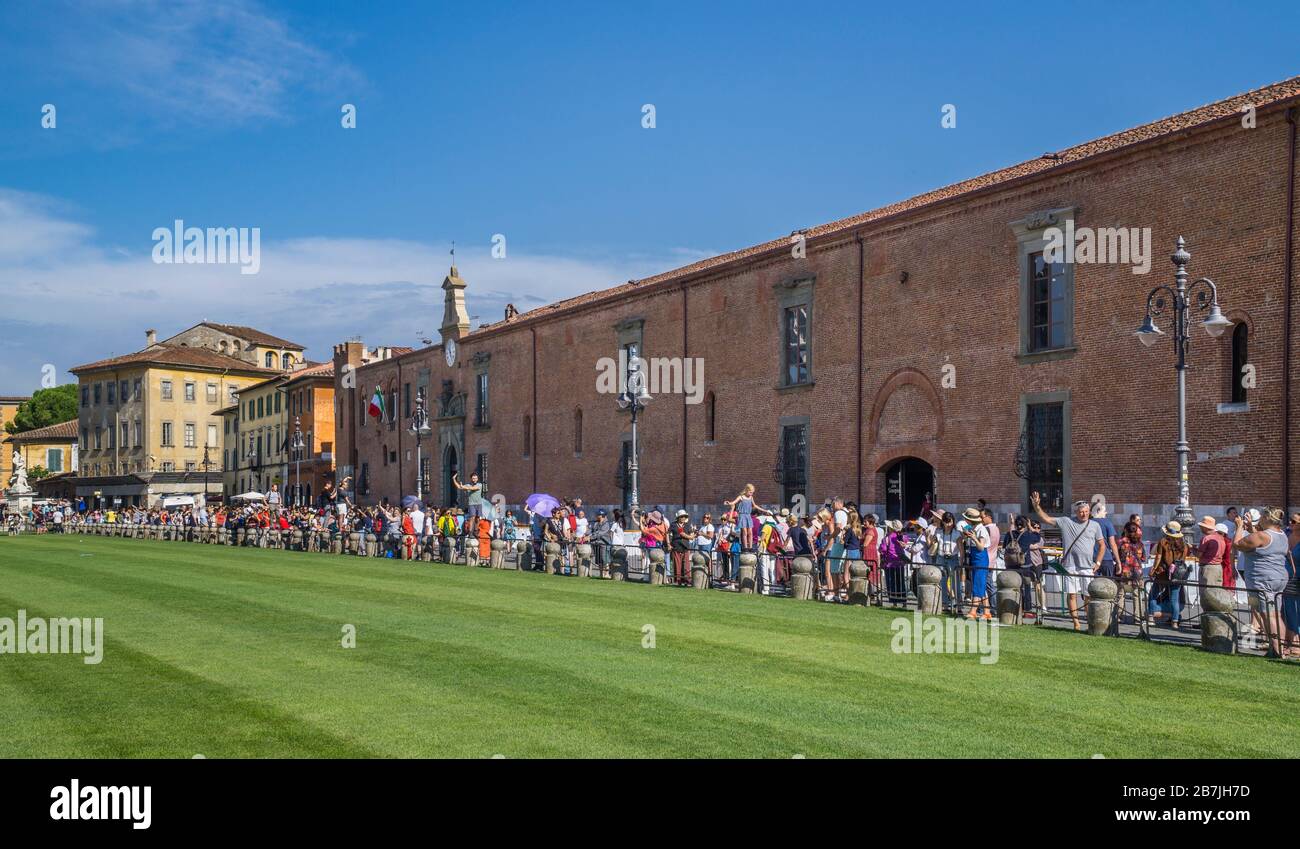 Los turistas admirando la Torre inclinada de Pisa desde la posición estratégica populat en el borde de la Piazza dei Miracoli en Ospedale Nuovo di Santo Spirito, Pisa, tu Foto de stock