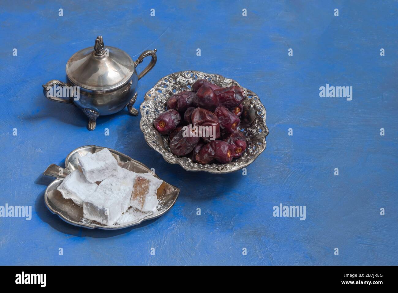 Ramadán dulce de alimentos, dátiles y lokum sobre fondo azul con espacio para copias Foto de stock