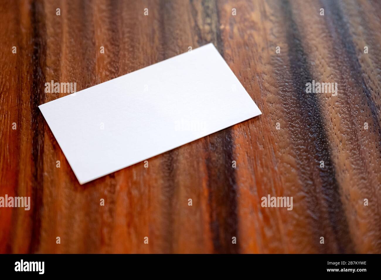 Una tarjeta de visita blanca en blanco sobre fondo de madera vintage Foto de stock