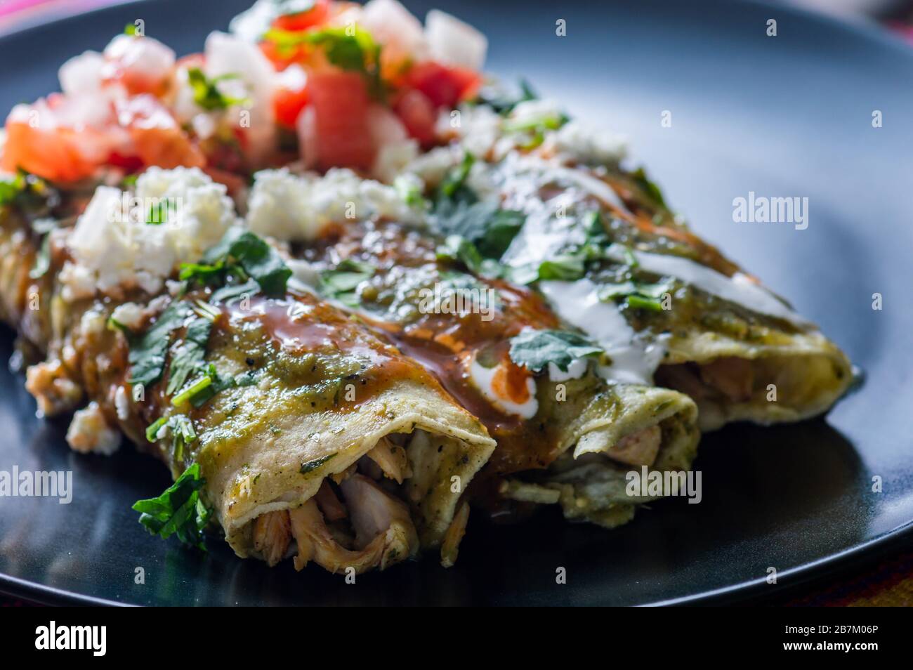Enchiladas Verdes O Enchiladas Verdes Tortillas Llenas De Pollo Y Cubiertas Con Salsa Verde Queso Y Crema Fotografia De Stock Alamy