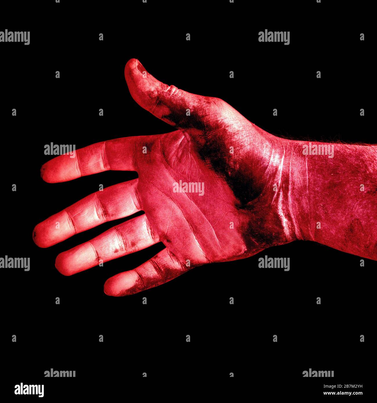 foto abstracta de una mano masculina roja sucia aislada sobre un fondo negro de cerca Foto de stock