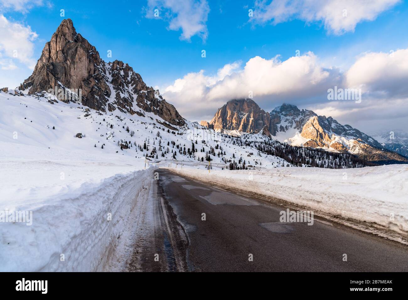 Camino vacío en un majestuoso paisaje nevado de montaña en los Alpes en un claro día de invierno Foto de stock
