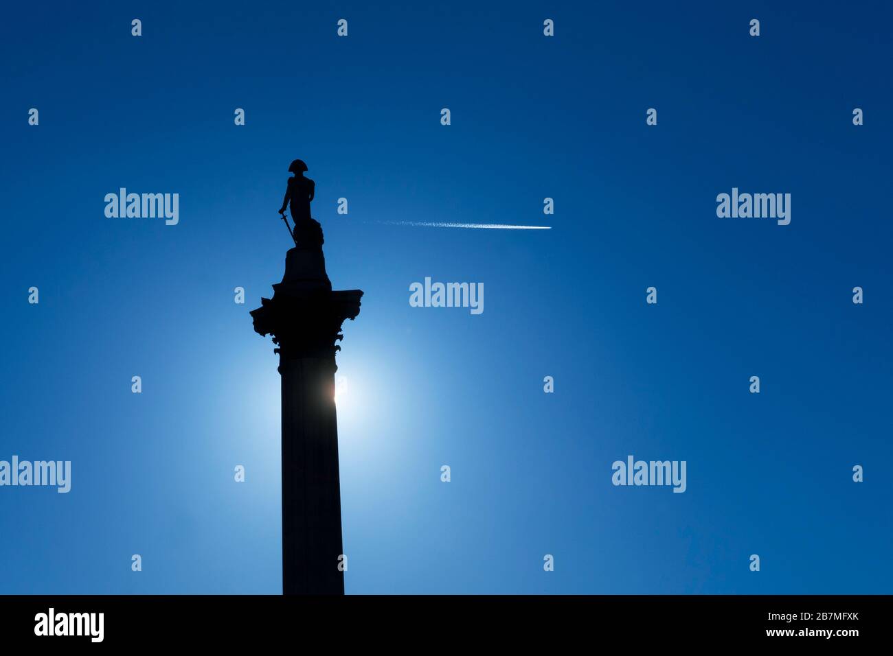 Columna de Nelson con rastro de vapor contra el sol y el cielo azul, Trafalgar Square, Londres, Inglaterra, Reino Unido, GB, Europa Foto de stock