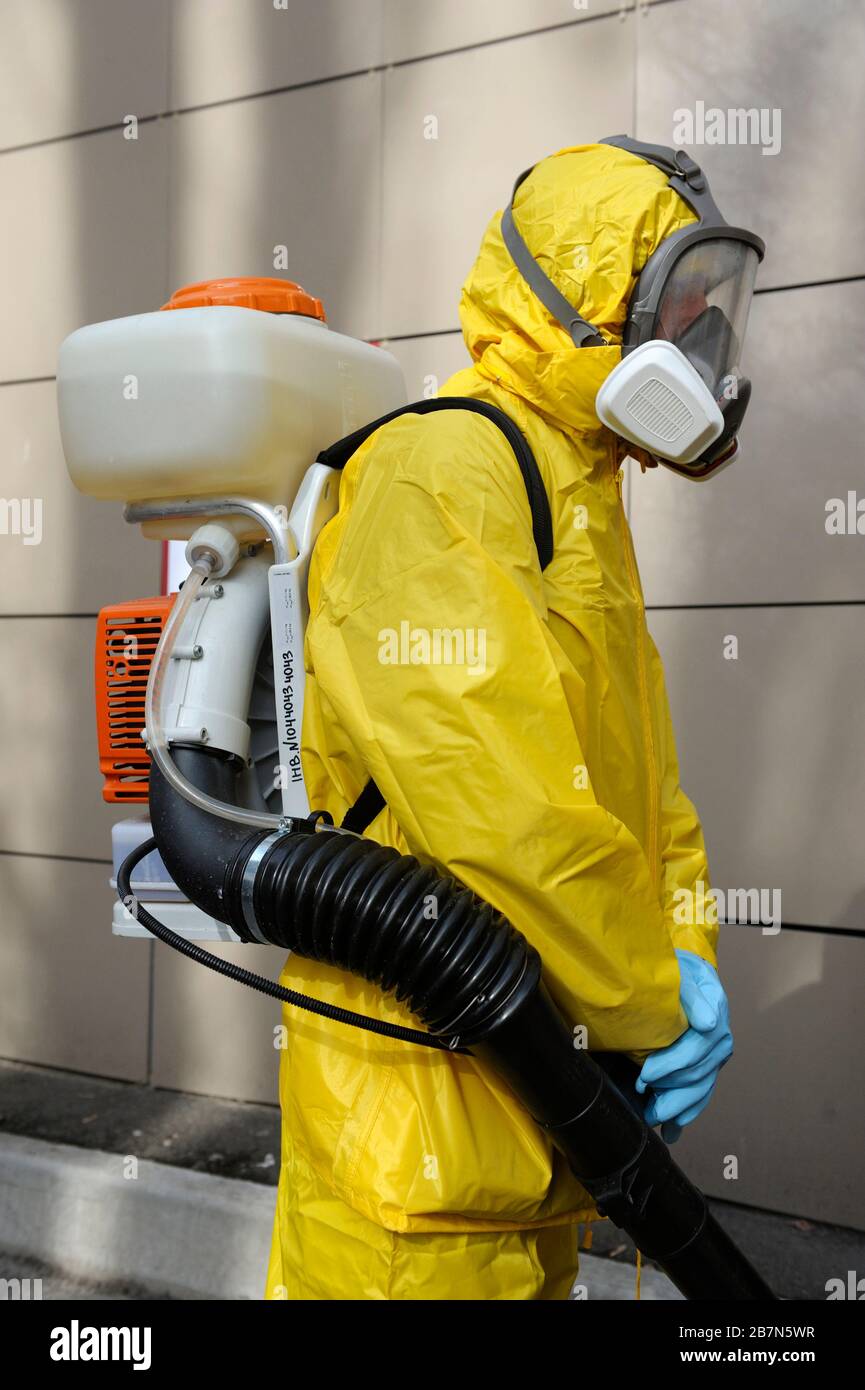 Paramédico con traje protector amarillo y máscara desinfectando coronavirus el atomizador motorizado de mochila pulverizador. 26 de febrero de 2020. Kie Fotografía de stock - Alamy