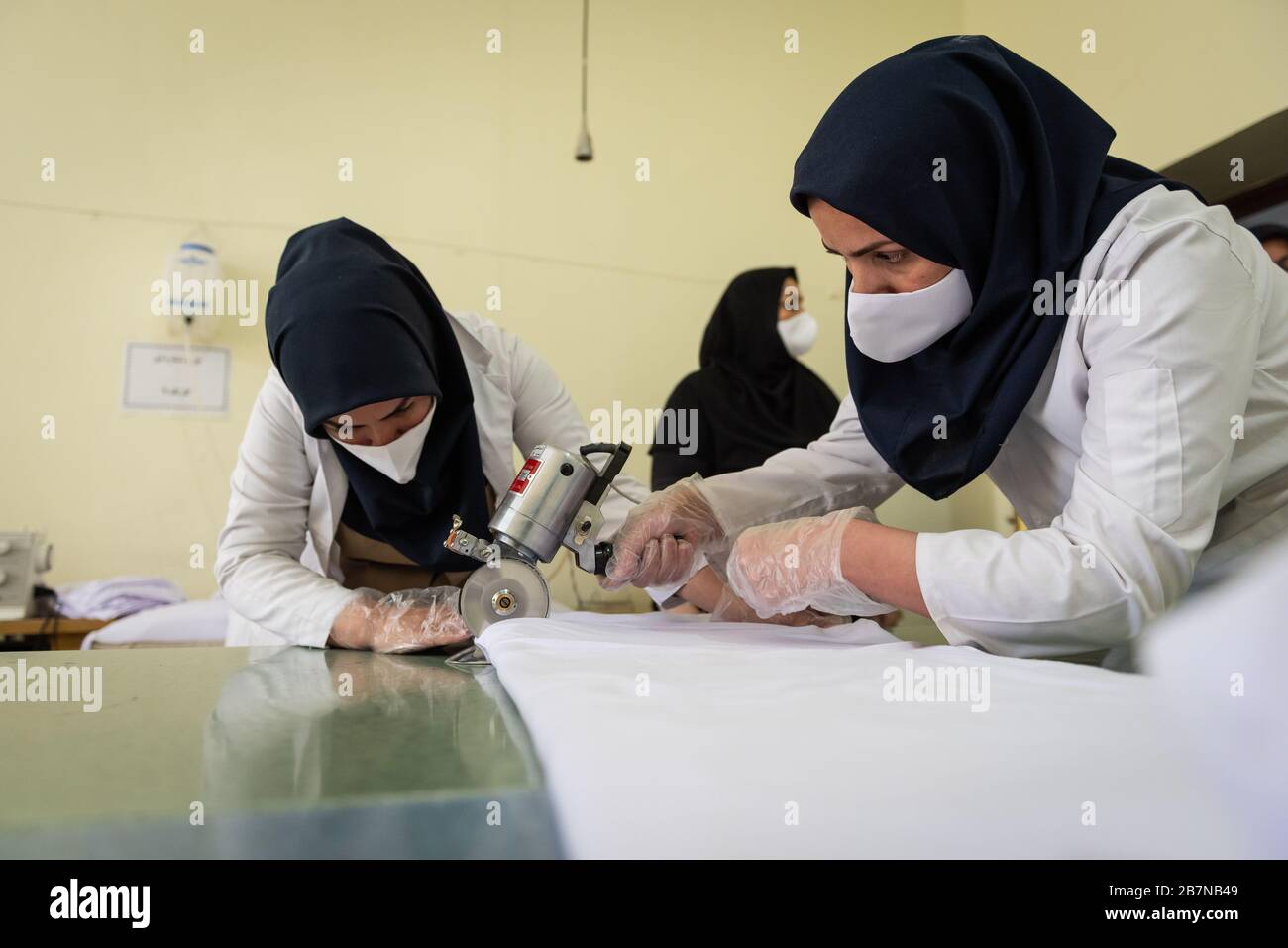 Un grupo de estudiantes y profesores en el campo del estudio de diseño de moda y telas, están creando voluntariamente cerca de 4000 máscaras diarias en la Universidad Vocacional de la ciudad de Shiraz, estas máscaras se distribuirán a las personas después de la esterilización, debido a la prevención de la propagación del Coronavirus (Covid19). Irán, provincia de Fars, ciudad de Shiraz. Foto de stock