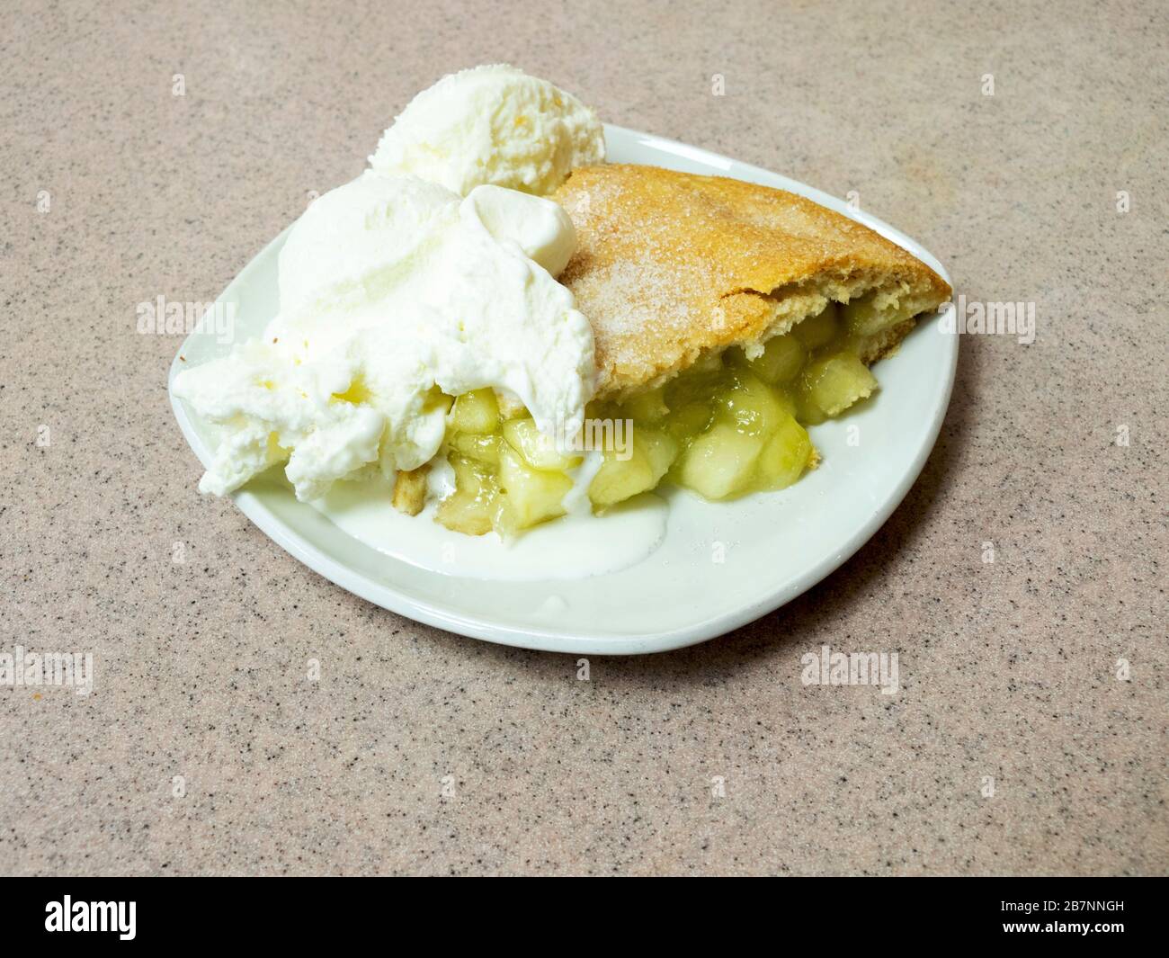 Una porción de tarta de manzana caliente con dos bolas de helado en North Yorkshire, Inglaterra Foto de stock