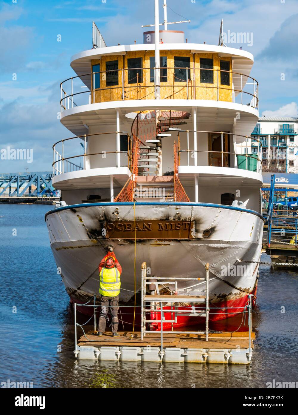 Trabajador de plataforma flotante que lleva a cabo el trabajo de conversión de barcos de Ocean Mist a un hotel flotante en Sunshine, The Shore, Leith, Edimburgo, Escocia, Reino Unido Foto de stock