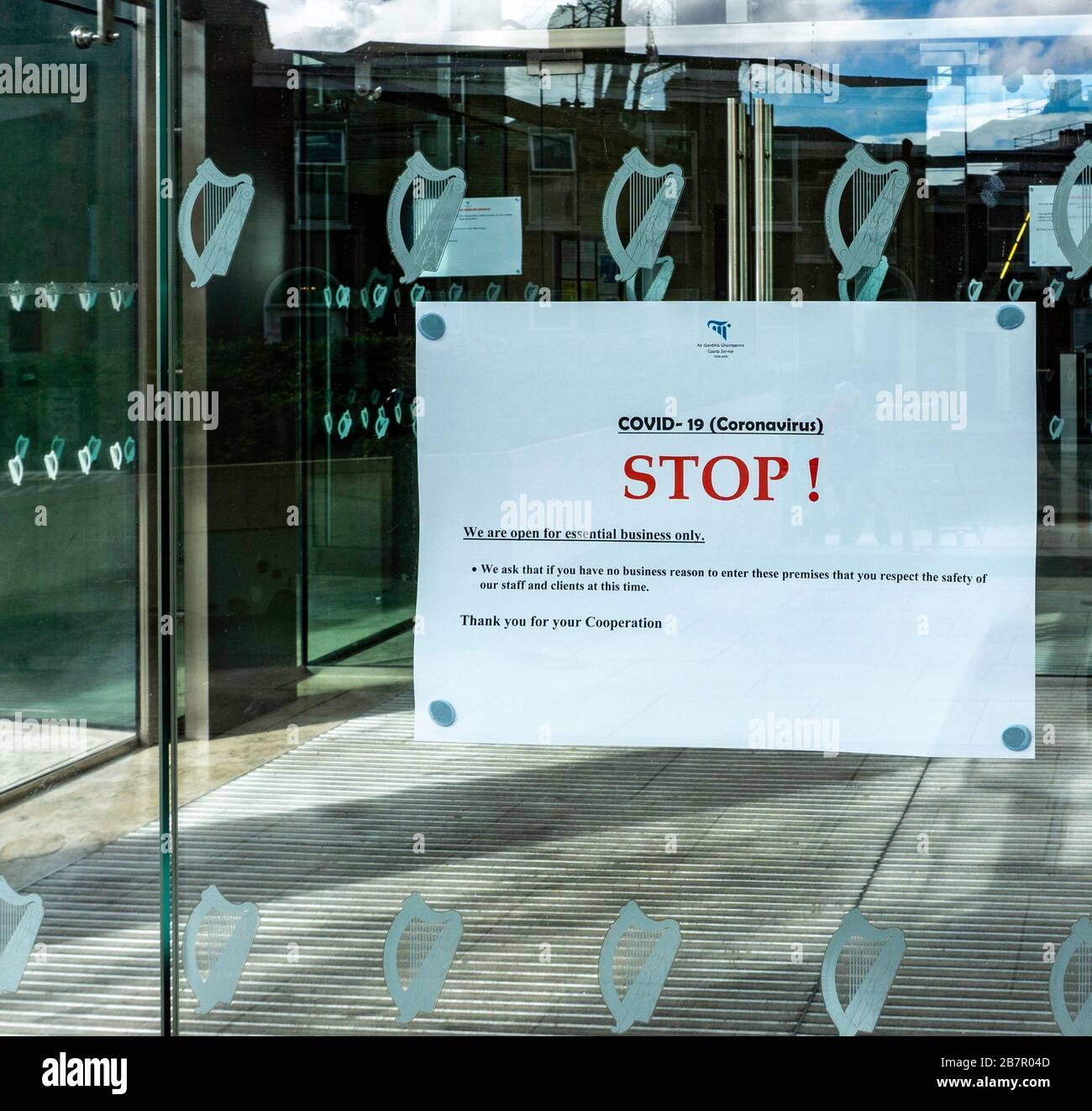Un cartel en la puerta del Tribunal Penal Central en Parkgate Street, Dublín, que informa que debido a Covid-19 están abiertos sólo para negocios esenciales. Foto de stock