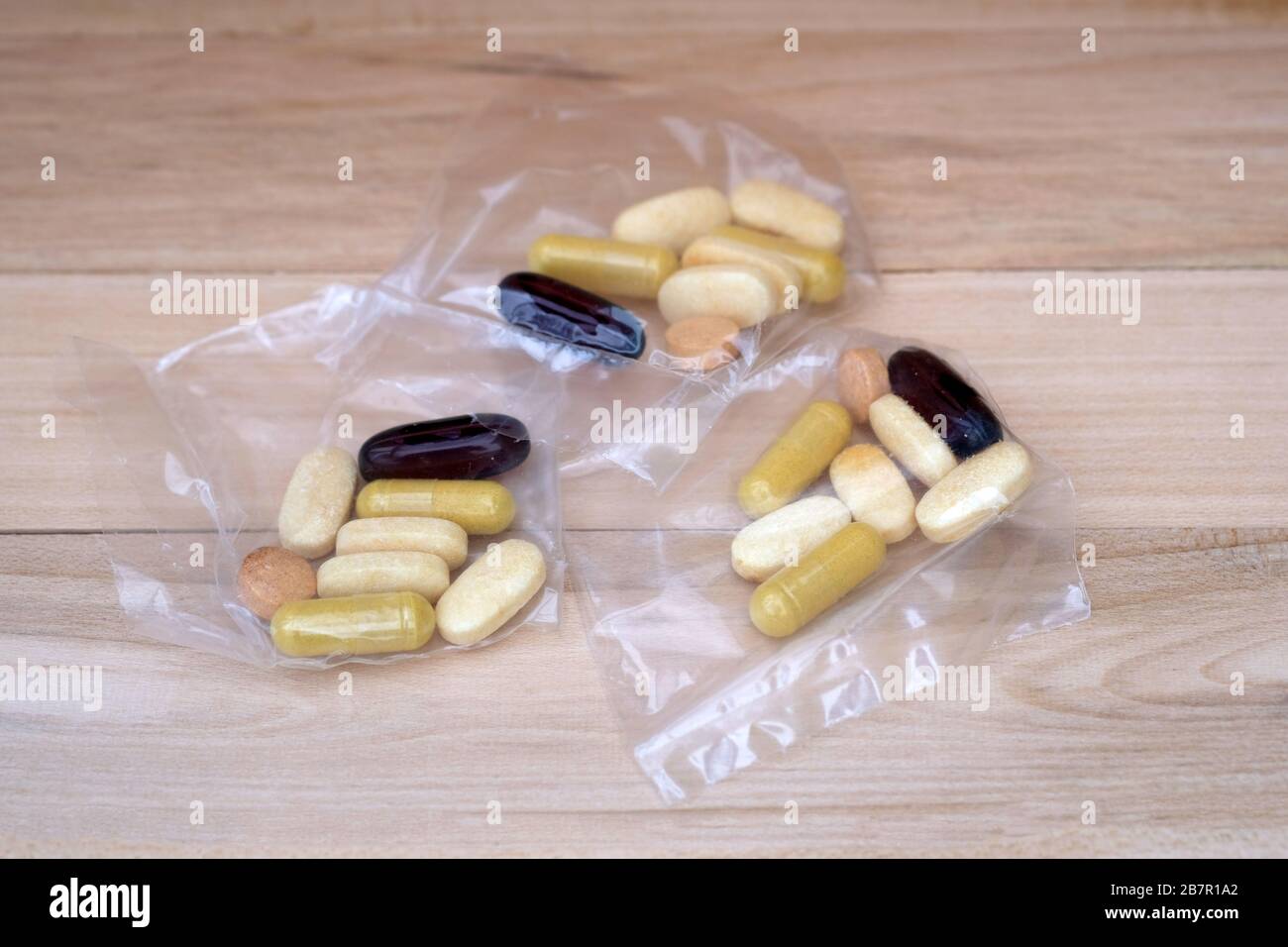 Pastillas en paquetes de celofán sobre un fondo de madera. Porciones de tabletas de diferentes tamaños y colores en bolsas. Suplementos dietéticos para mantener las articulaciones an Fotografía de stock - Alamy Pastillas en paquetes de celofán sobre un fondo de madera. Porciones de tabletas de diferentes tamaños y colores en bolsas. Suplementos dietéticos para mantener las articulaciones an Fotografía de stock - Alamy
