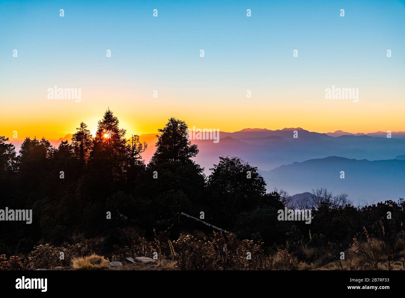 Las crestas de montaña apiladas se ven durante la hora dorada de la puesta de sol desde Poonhill Ghorepani Nepal Foto de stock