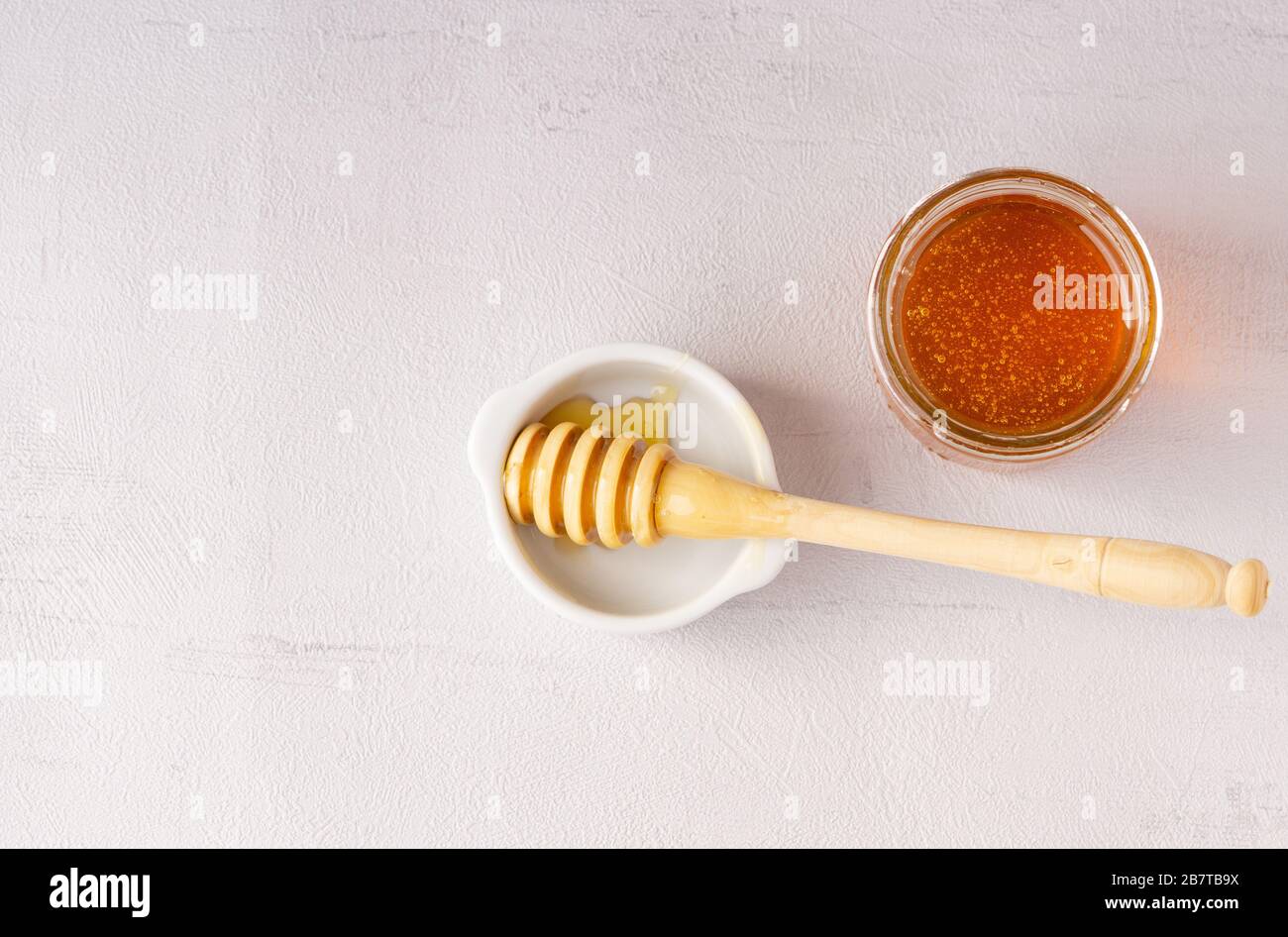 Jarra de miel, olla, cuchara de madera. Salud. Inmunidad. Aislado. Vista superior. Foto de stock