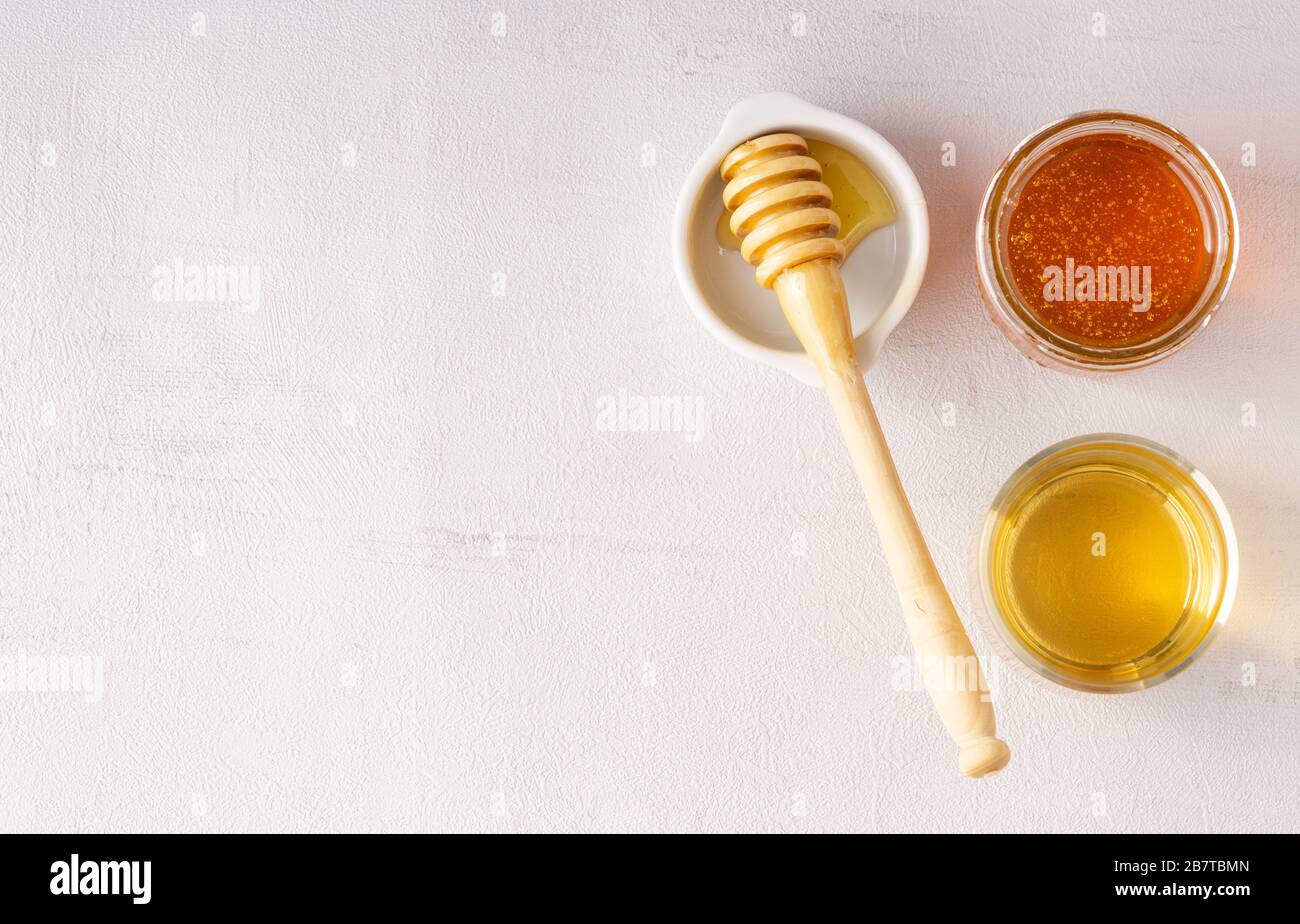 Jarra de miel, olla, taza de té, cuchara de madera. Salud. Inmunidad. Aislado Foto de stock