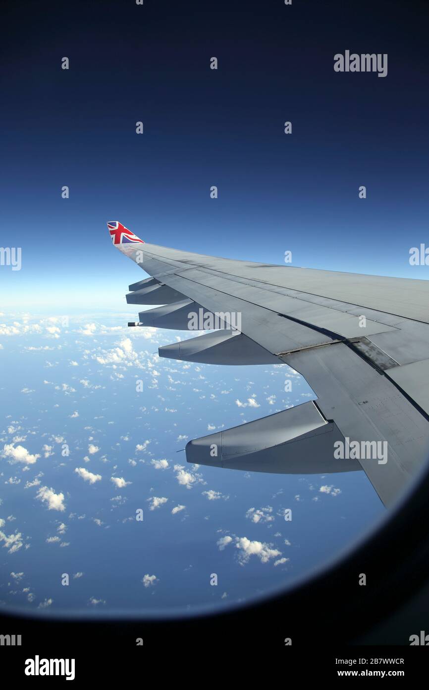 Avión Boeing 747-400 (744) en vuelo Vista del ala mostrando las pistas de flap a través de la ventana Foto de stock