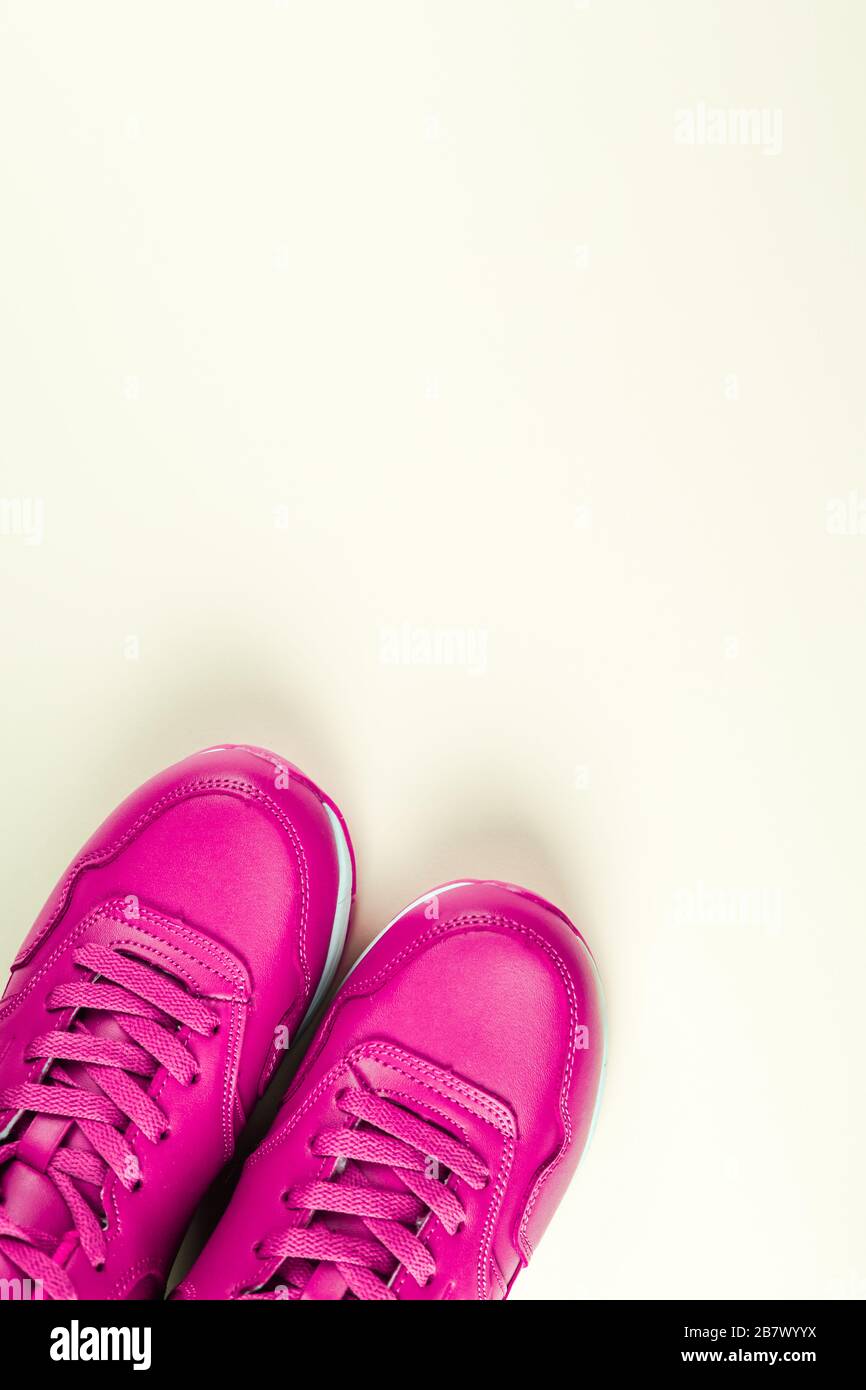 Zapatillas de lona de color rosa brillante sobre fondo blanco. Concepto de  deporte femenino y estilo de vida saludable. Colocar para texto,  disposición plana, vista superior Fotografía de stock - Alamy