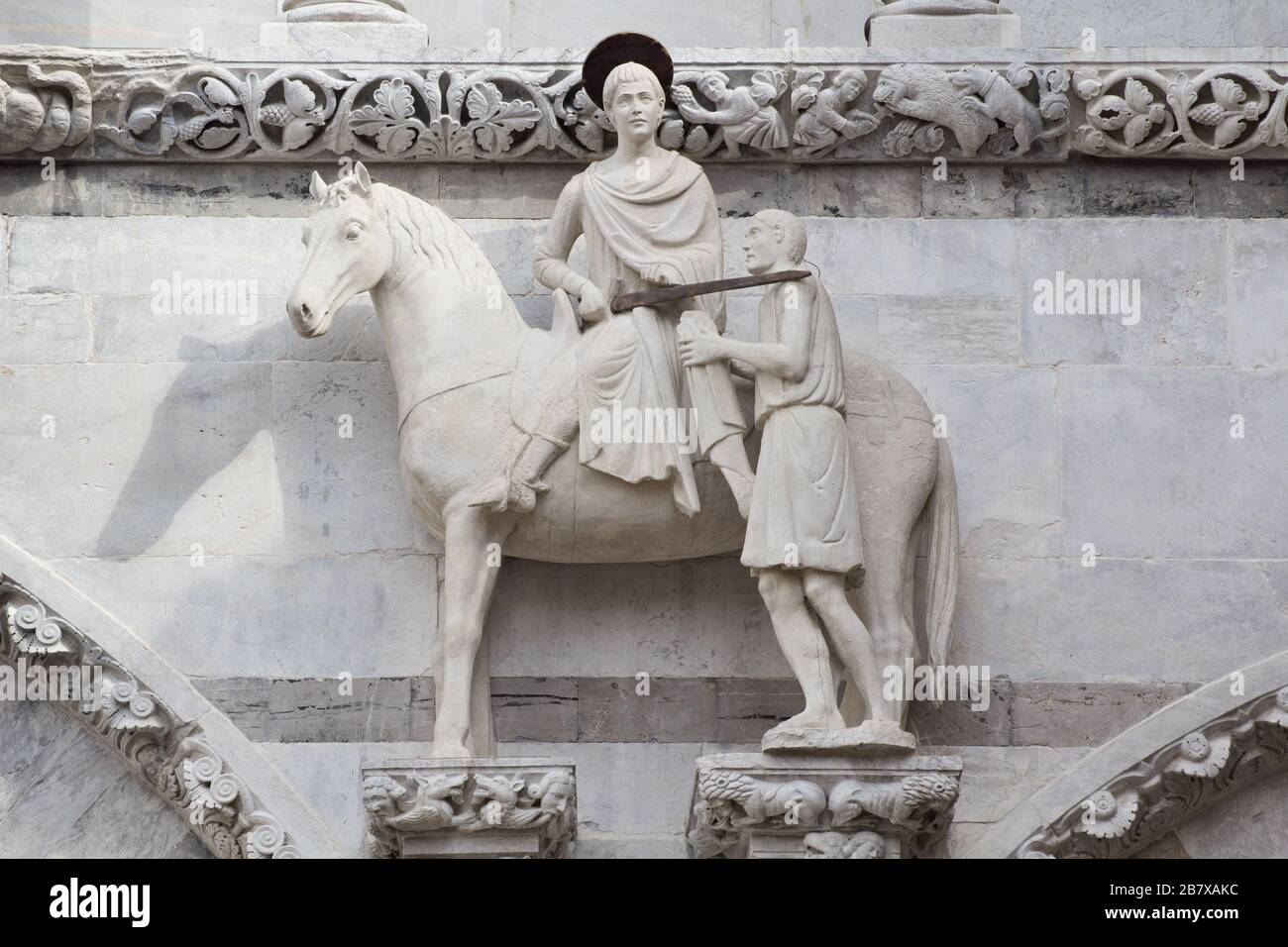 La estatua medieval de San Martín y el beggar en la fachada de la Catedral de Lucca, Toscana, Italia Foto de stock