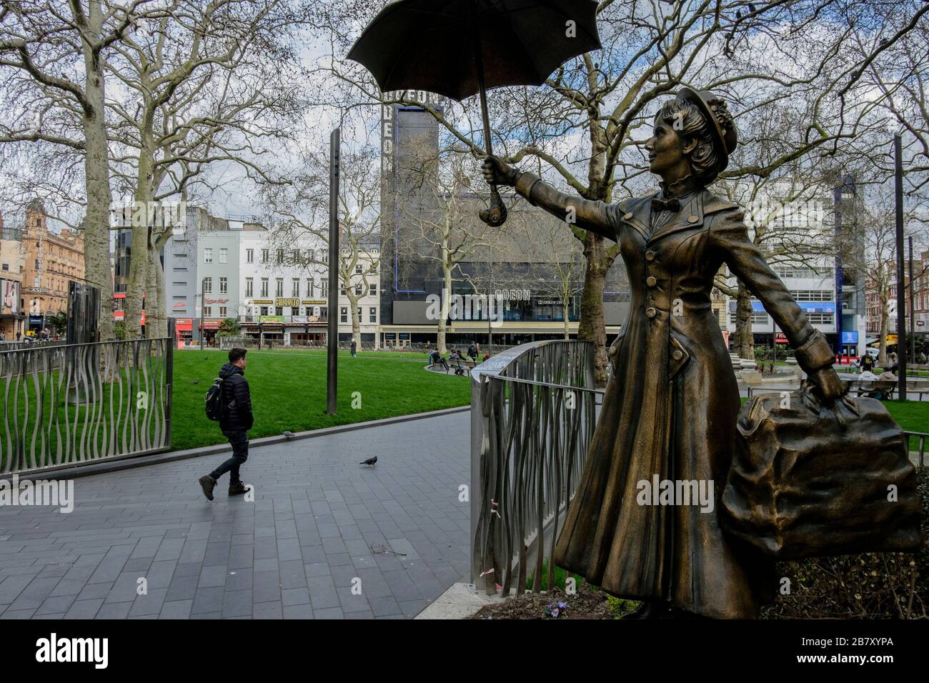 Londres, Reino Unido 18 de marzo de 2020. Una estatua de personaje de cine, Mary Poppins, se encuentra en una plaza de Leicester casi desierta, una zona normalmente ocupada con los visitantes de la capital. Foto de stock