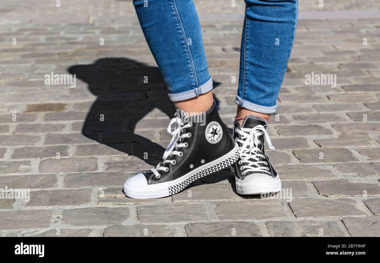 Francia - Spetember 2, 2019: la imagen de la inferior de las piernas del adolescente en jeans y zapatillas Converse Star en una calle adoquinada Fotografía de stock - Alamy