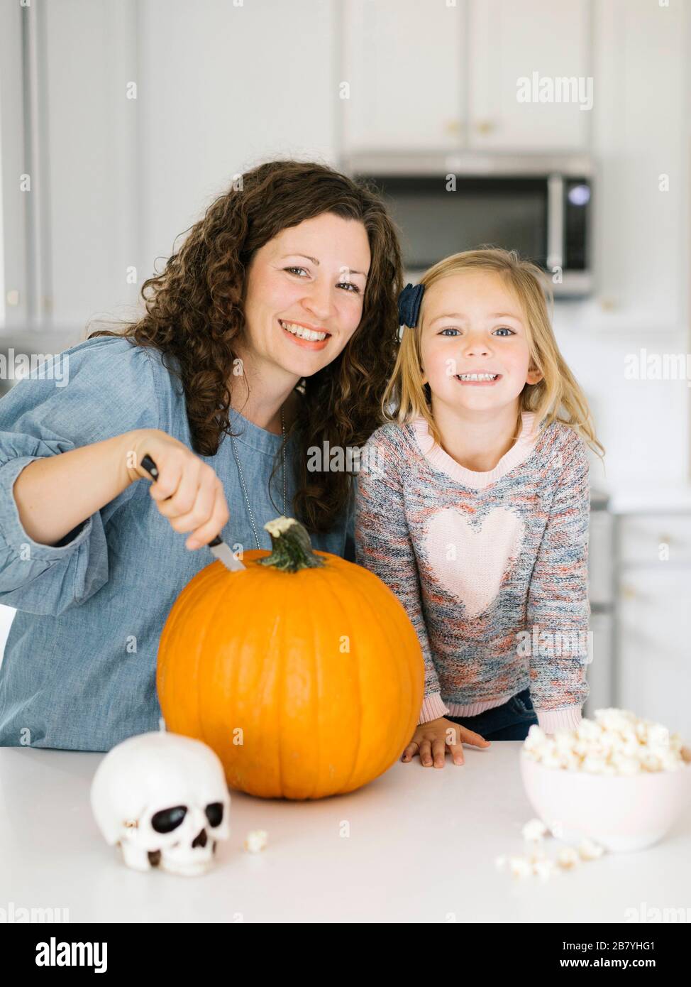 Madre e hija tallando calabaza para Halloween Foto de stock