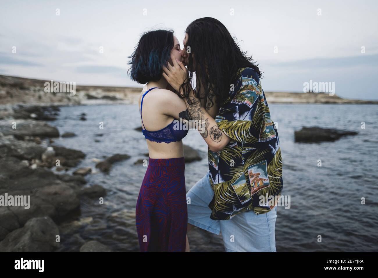 Joven pareja besándose en la playa Foto de stock
