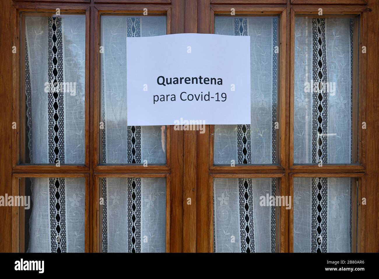 El signo cuarentena para el virus Covid-19 en español sobre una ventana de madera Foto de stock